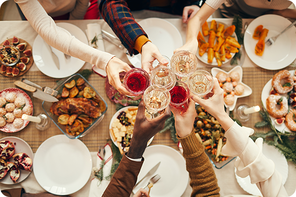Sechs Menschen stoßen über reich gedecktem Tisch an